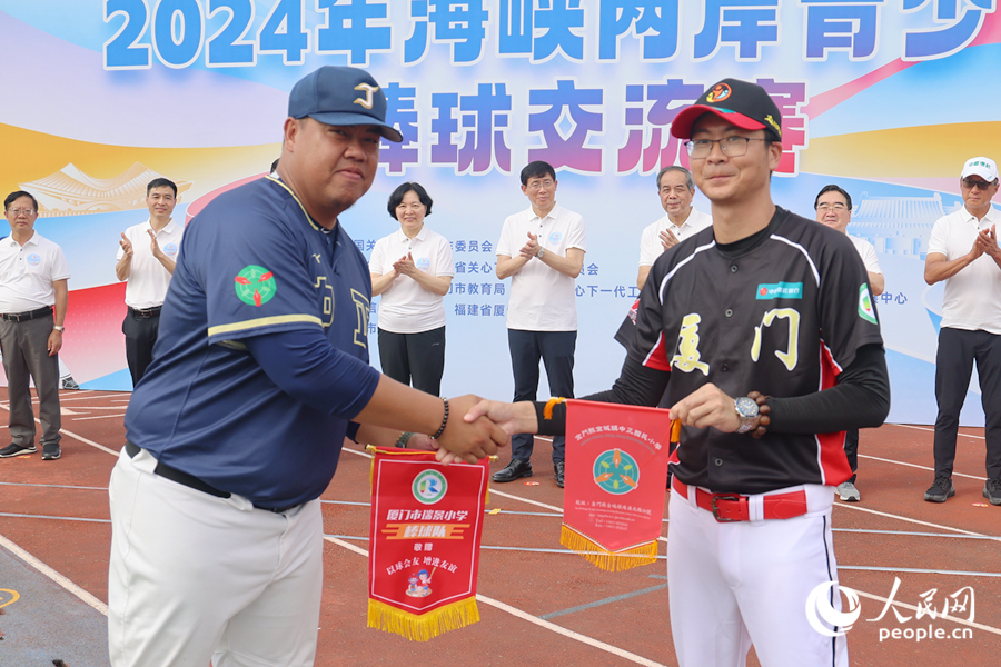 海峡两岸棒球队教练互赠队旗。人民网记者 陈博摄