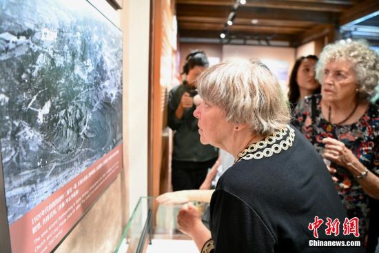 图为美国穆蔼仁家族后人穆言灵(前)与柯志仁家族后人毕乐华观看鼓岭历史照片。中新社记者 王东明 摄