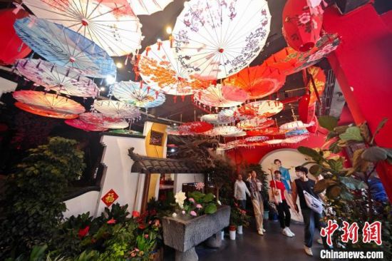 7月8日，福建福州，游客在三坊七巷古厝观看非遗文化产品。中新社记者 王东明 摄