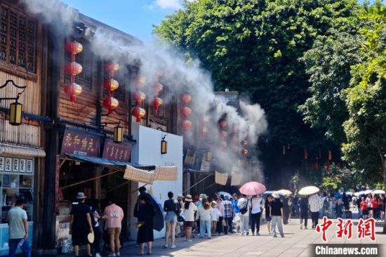 7月8日，福建福州，南后街古厝喷水雾为过往游人降温。中新社记者 王东明 摄