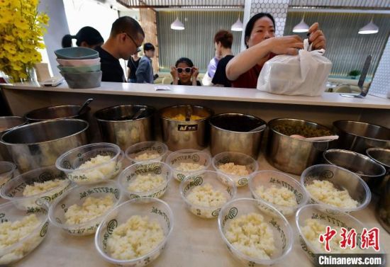 7月10日，在福建省福州市长乐区一家冰饭店，市民在购买打包好的冰饭。中新社记者 张斌 摄
