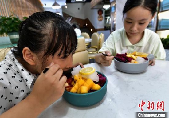 7月10日，在福建省福州市长乐区一家冰饭店，小朋友在品尝冰饭。中新社记者 张斌 摄