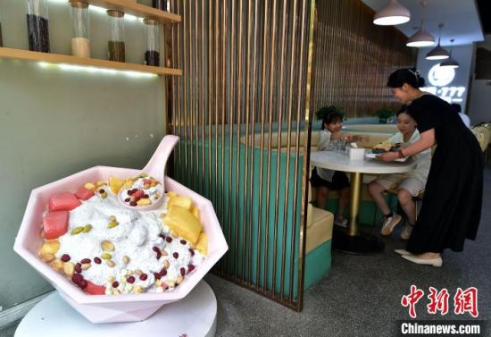7月10日，在福建省福州市长乐区一家冰饭店，小朋友在等候品尝冰饭。中新社记者 张斌 摄
