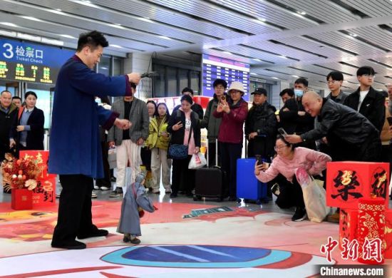 1月14日，福建泉州站候车大厅，木偶戏表演吸引旅客观看。中新社记者 吕明 摄