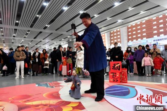 1月14日，福建泉州站候车大厅，木偶戏表演吸引旅客观看。中新社记者 吕明 摄