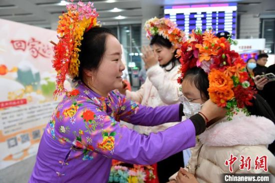 1月14日，福建泉州站候车大厅，旅客体验簪花围。中新社记者 吕明 摄