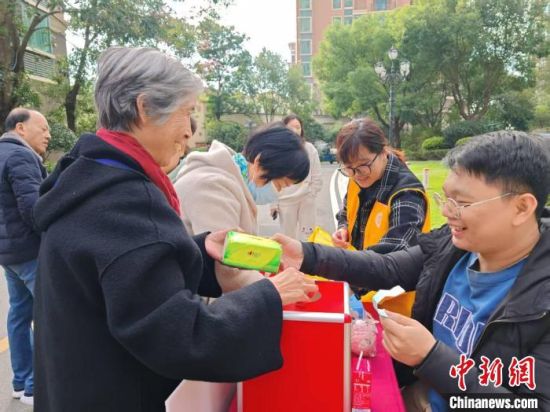 2024年12月20日，黄家俊(右一)参与其服务的社区内进行冬至习俗活动，小区居民在活动中兑换礼品。 受访者供图