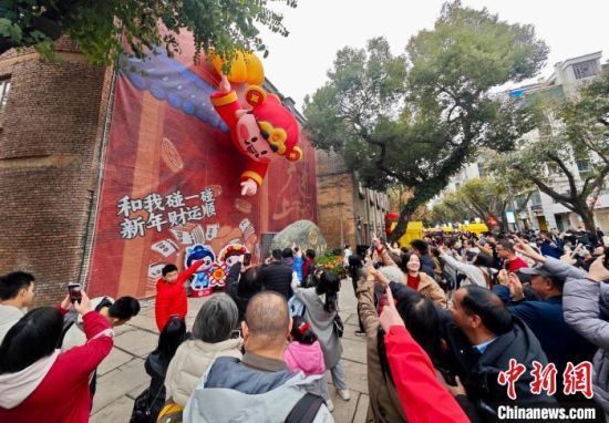 2月2日，农历正月初五，市民和游客与“财神爷”互动留影。中新社记者 王东明 摄
