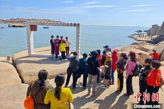 3月1日，福建平潭68海里景区，游客在“两岸同心窗”景点留影。68海里景区，以猴研岛为核心，是中国大陆离台湾岛最近的地方，与台湾新竹南寮渔港相距68海里。中新社记者 王东明 摄