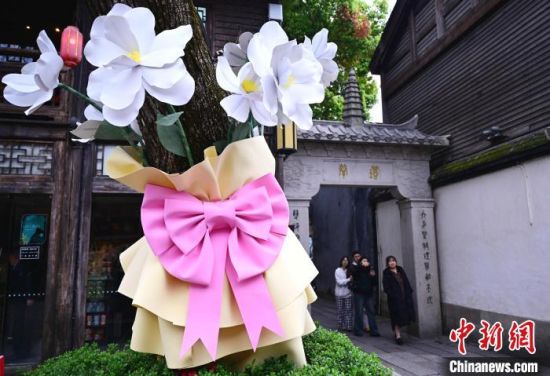 3月17日，福州三坊七巷南后街，街头许多原来光秃秃的树木底部被扮靓成“一束花”，为街区的春天增添了一抹亮色。中新社记者 张斌 摄