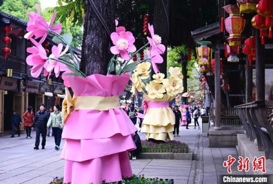 3月17日，福州三坊七巷南后街，街头许多原来光秃秃的树木底部被扮靓成“一束花”，为街区的春天增添了一抹亮色。中新社记者 张斌 摄