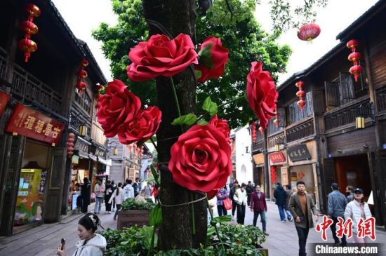 3月17日，福州三坊七巷南后街，街头许多原来光秃秃的树木底部被扮靓成“一束花”，为街区的春天增添了一抹亮色。中新社记者 张斌 摄