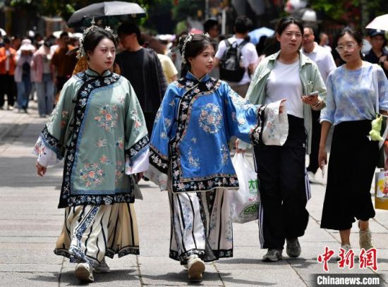 图为5月5日，游客头戴“三条簪”身着汉服，漫步在福州三坊七巷。中新社记者 张斌 摄
