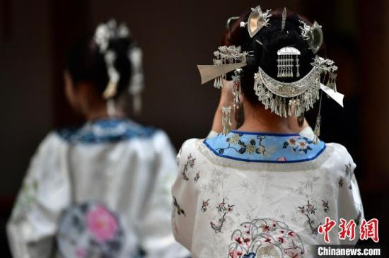 图为5月5日，游客头戴“三条簪”在福州三坊七巷打卡留影。中新社记者 张斌 摄