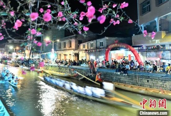 5月27日晚，三溪村村民在溪中夜竞龙舟。中新社记者 张斌 摄