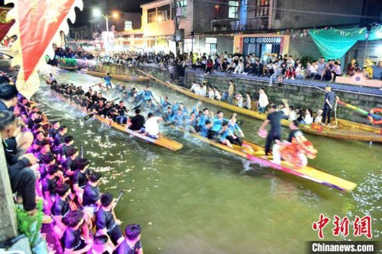 5月27日晚，三溪村村民在溪中夜竞龙舟。中新社记者 张斌 摄