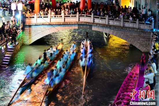 5月27日晚，三溪村村民在溪中夜竞龙舟。中新社记者 张斌 摄